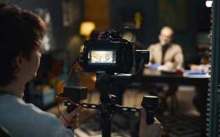 Operator Shooting Video Of Podcast Operator using professional camera to shoot video of podcast in studio